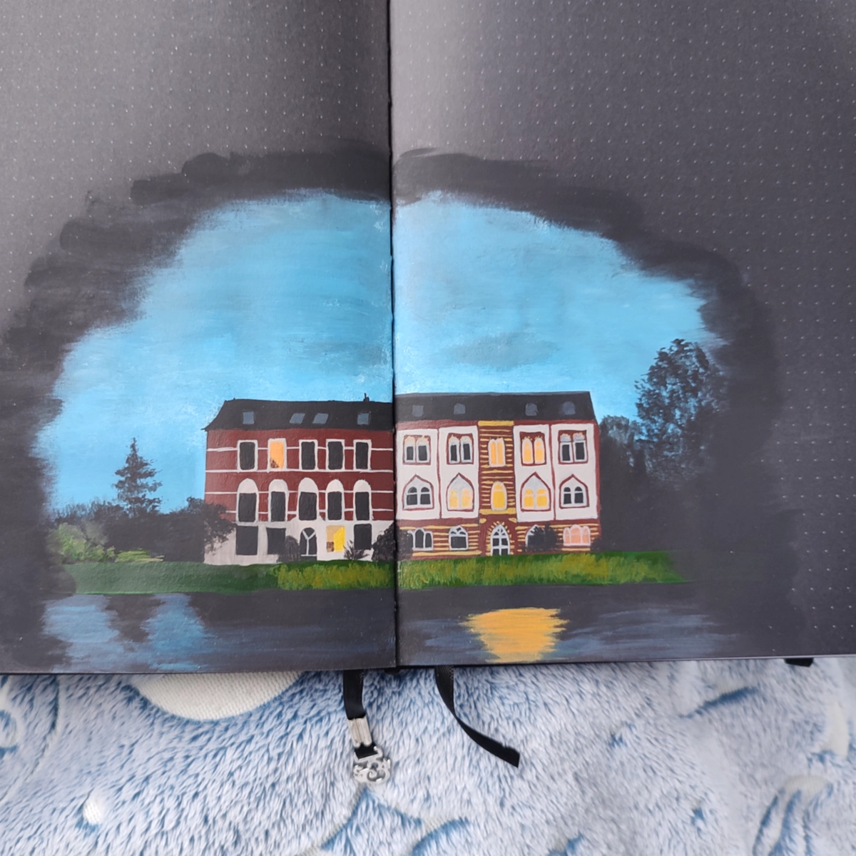 An acrylic painting of two old houses in a journal